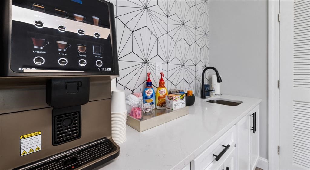 a white kitchen with a microwave and a sink