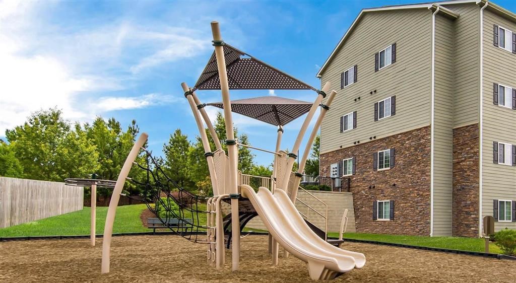 a playground with a slide and a chair in a backyard