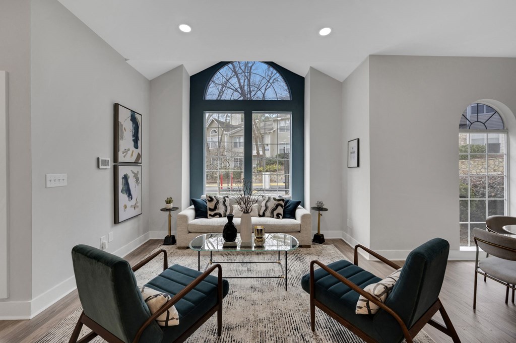 a living room with a large window and a couch and chairs