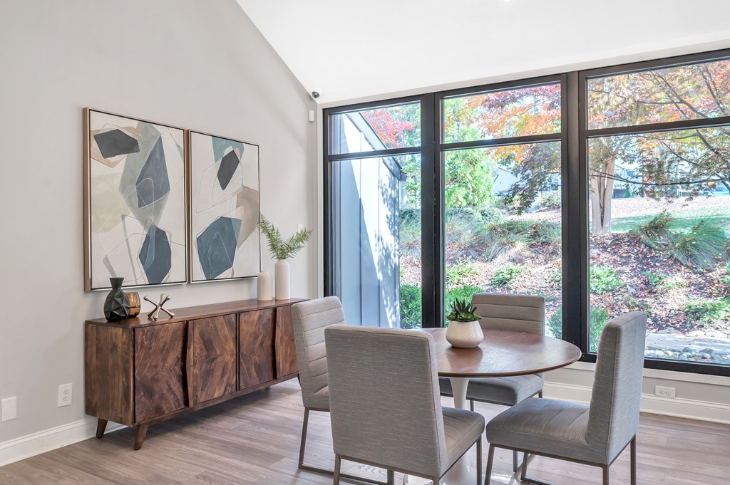 a dining room with a table and chairs and a large window