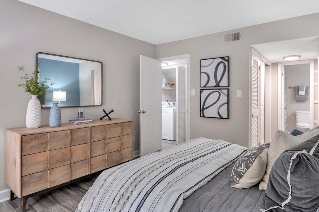 a bedroom with a bed and a dresser with a mirror