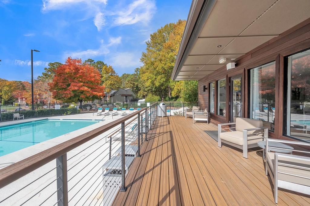 the pool area of a building with a pool and deck with chairs