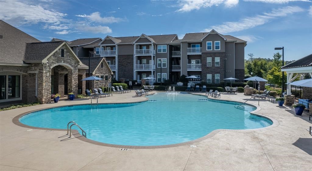 a large swimming pool with an apartment building in the background