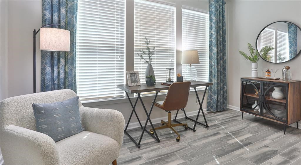 a living room with a chair and a desk