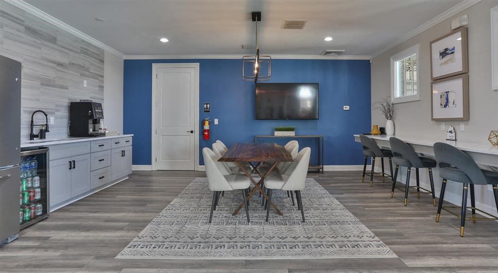 a dining room and kitchen with a table and chairs and a television