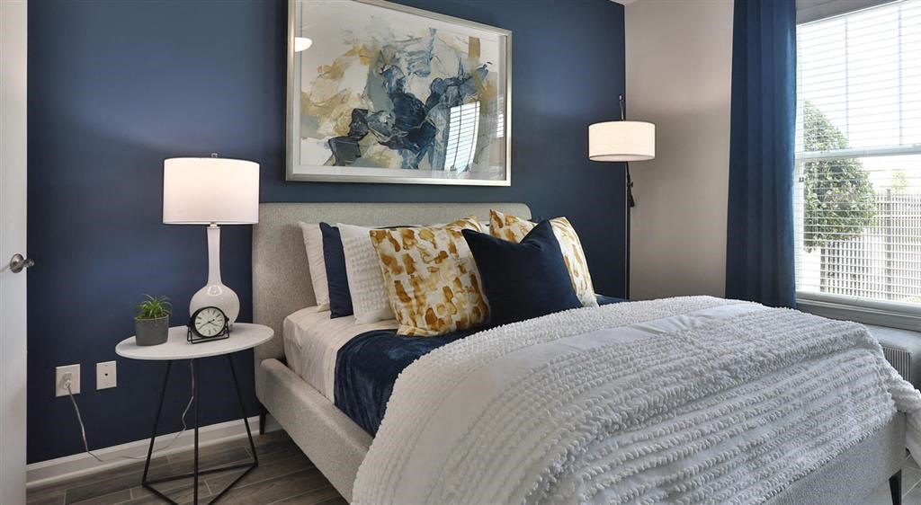 a bedroom with a bed and a painting on the wall