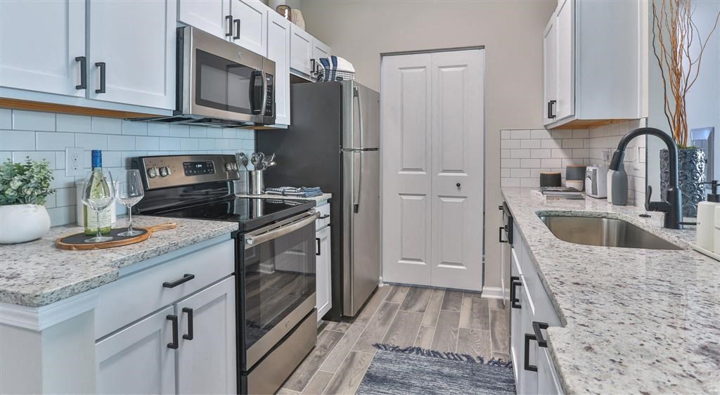 a kitchen with a stove refrigerator and sink