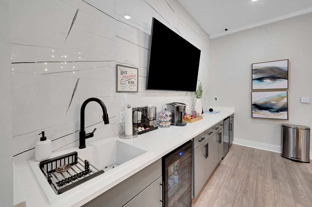 a white kitchen with a sink and a tv