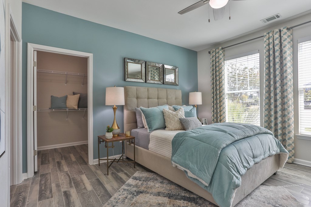 A bedroom with a large bed and a dresser with a mirror above it.
