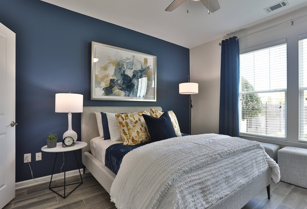 A bedroom with a large bed and a painting on the wall.