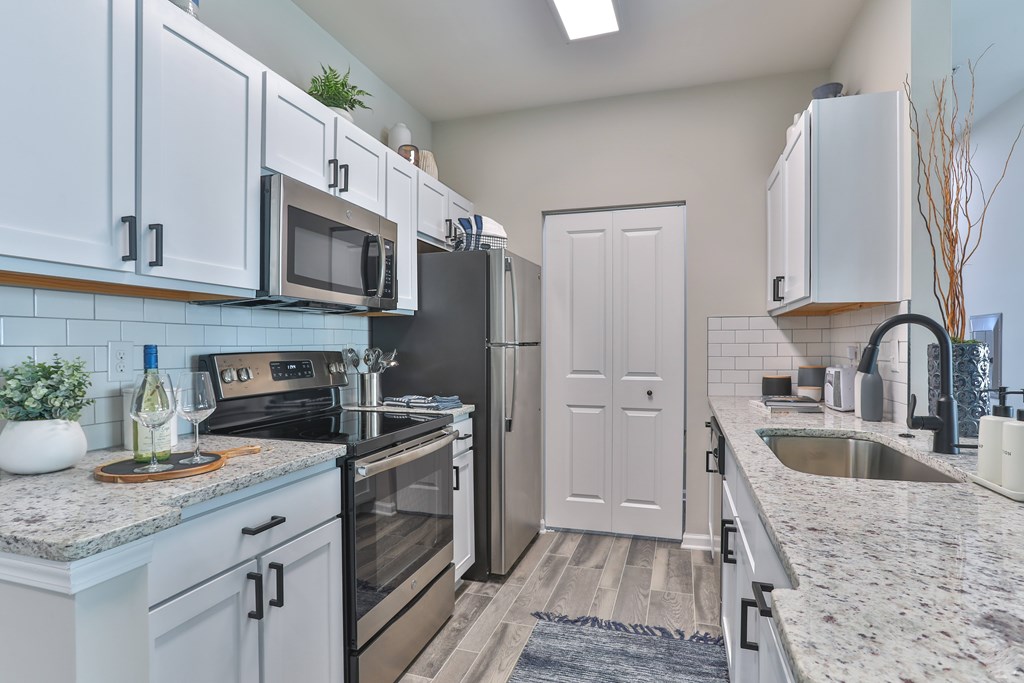A kitchen with a white door and a marble countertop.