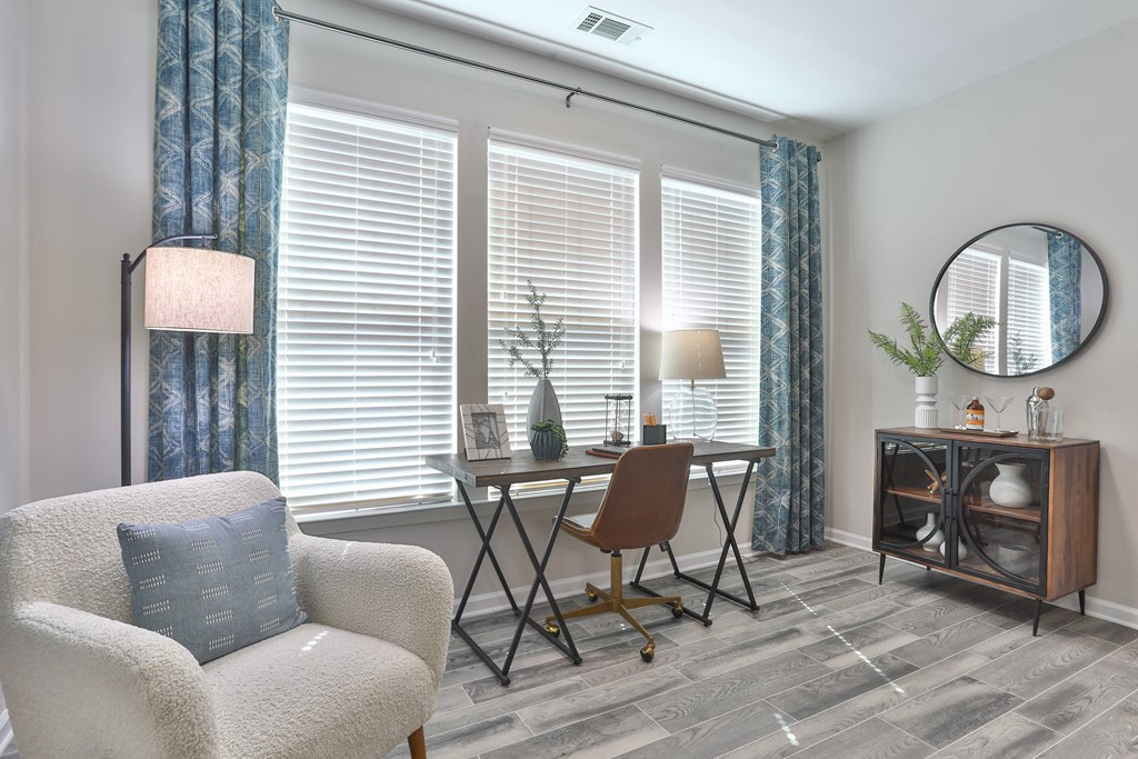 A cozy room with a chair, a table, and a lamp.