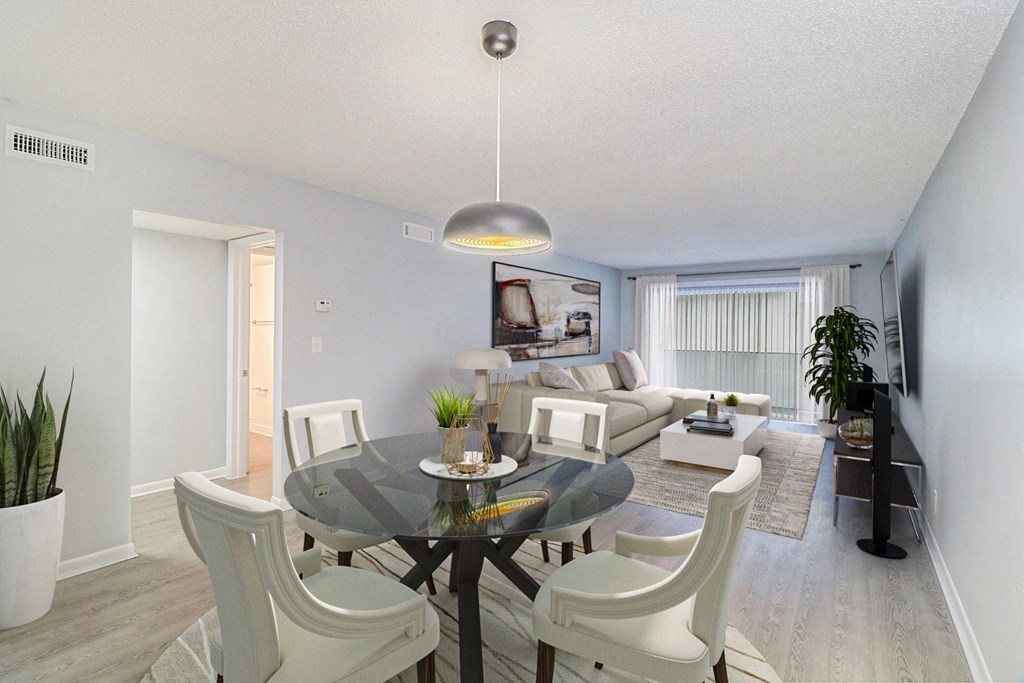 an open living room and dining room with a glass table and chairs