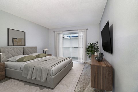 a bedroom with a bed and a tv on the wall