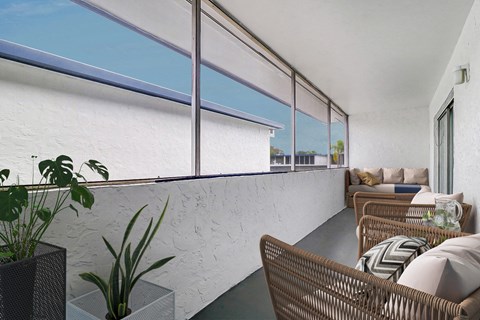 a living room with large windows and a white brick wall