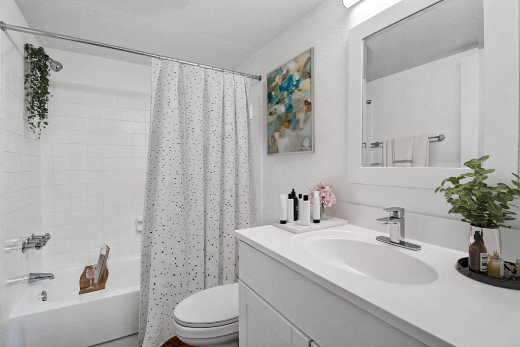 a white bathroom with a shower and a sink and a toilet