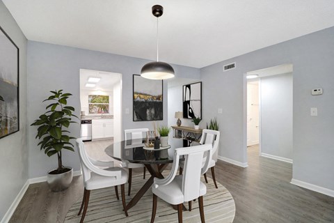 a dining room with white chairs and a glass table