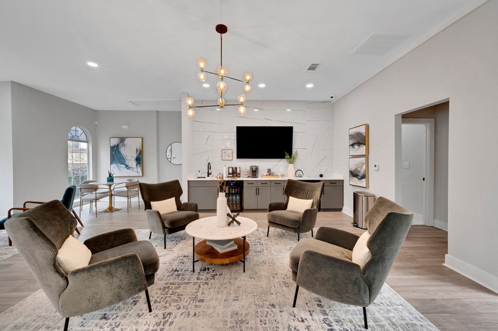 a living room with chairs and a table and a kitchen