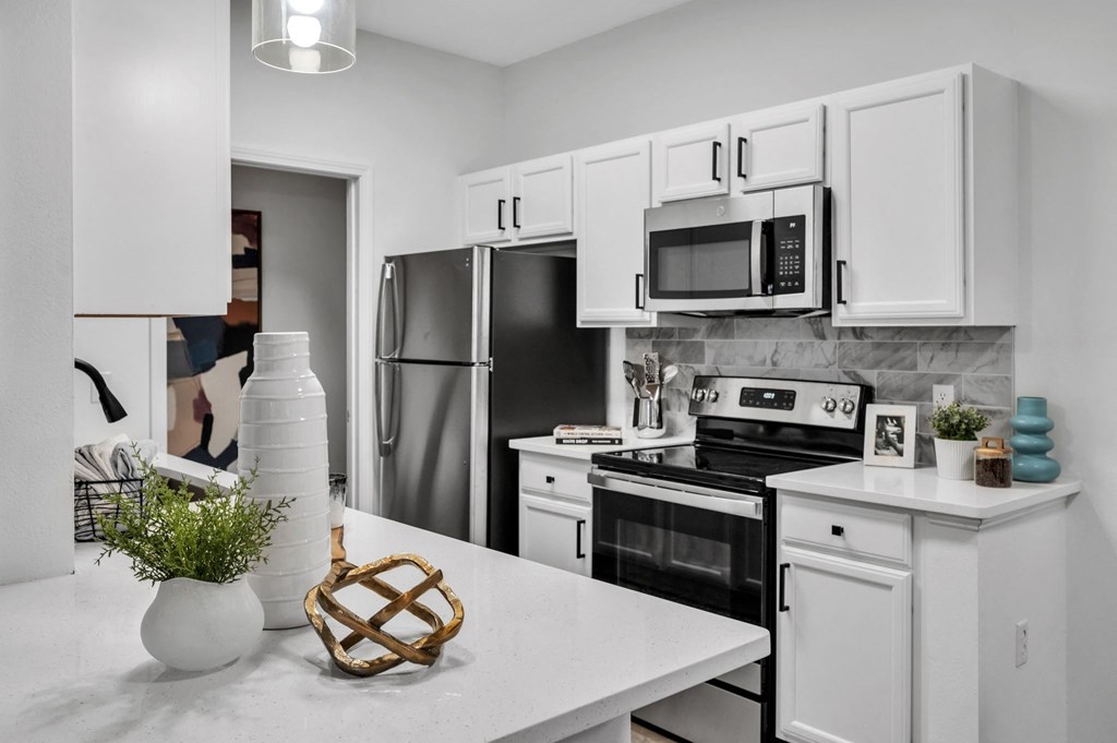 a kitchen with white cabinets and stainless steel appliances