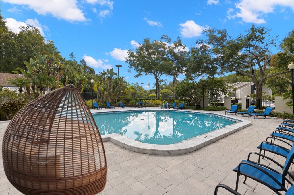 a swimming pool with chairs and a hammock next to it