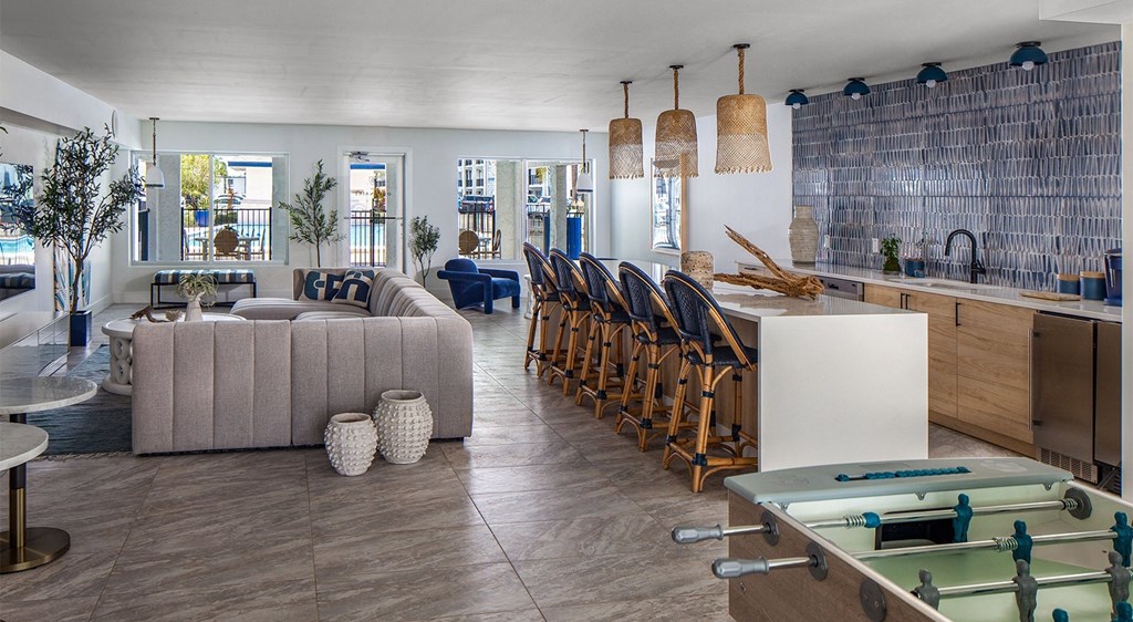 a living room and kitchen with a bar and a pool table