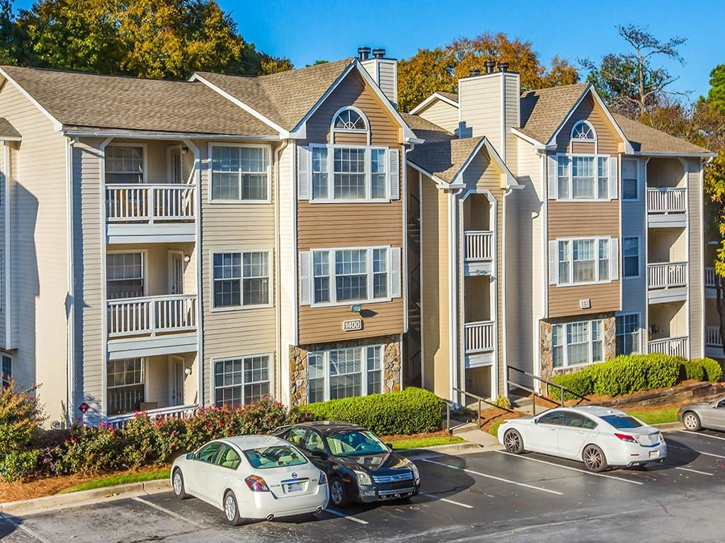 an apartment building with cars parked in front of it