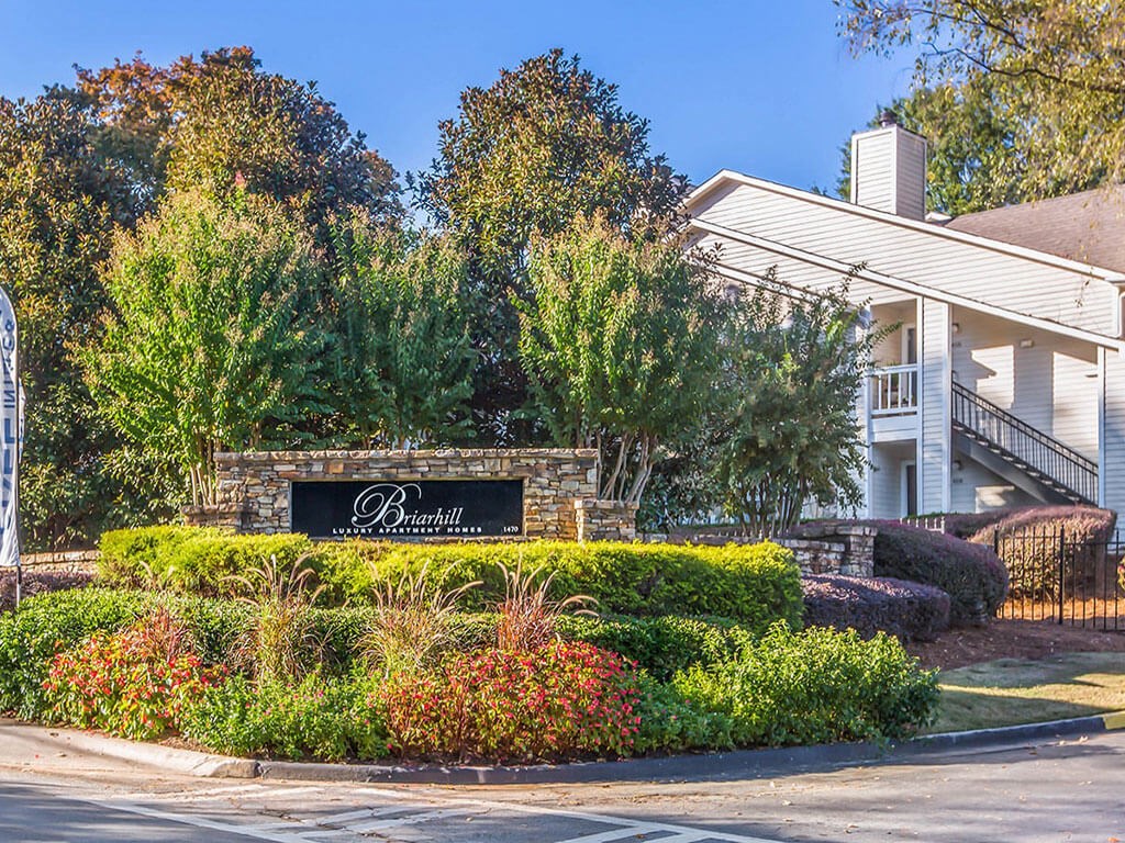 a building with a sign in front of a garden