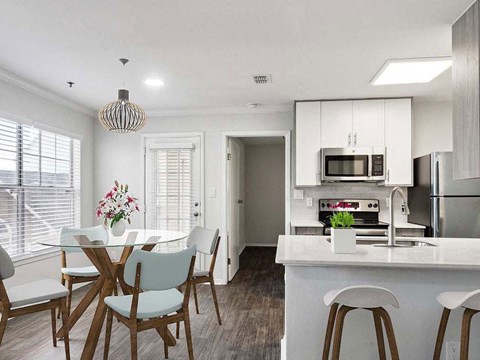 a kitchen and dining area with a white counter top