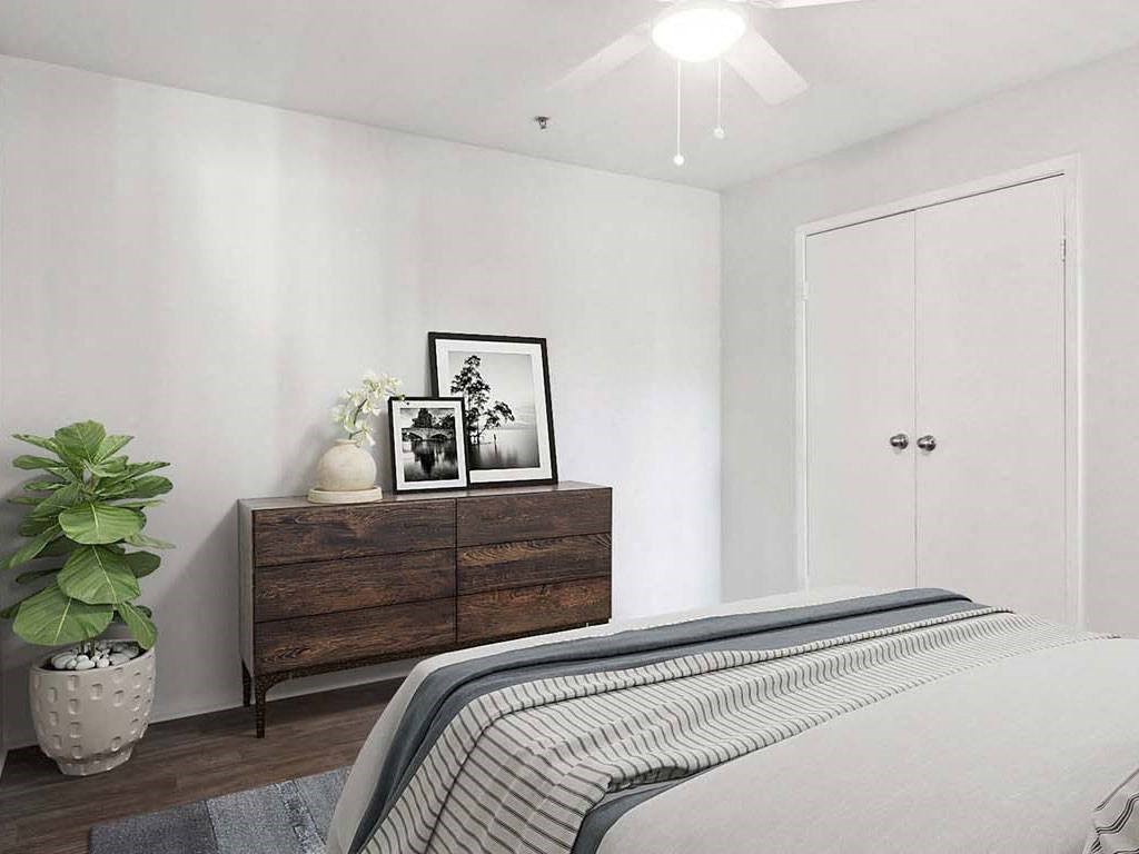 a bedroom with a bed and a dresser with pictures on it