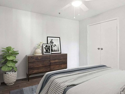 a bedroom with a bed and a dresser with pictures on it