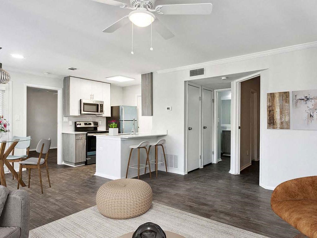 a living room and kitchen with a ceiling fan