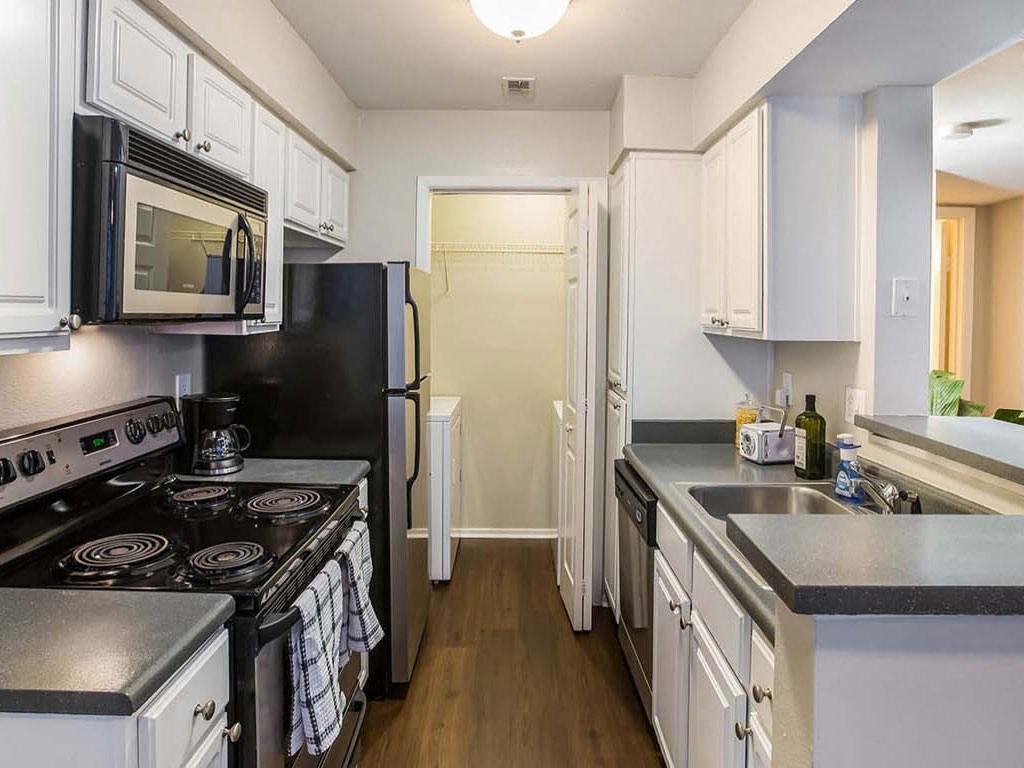 a kitchen with a stove and a refrigerator and a sink