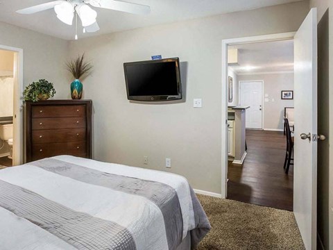 a bedroom with a bed and a television on the wall