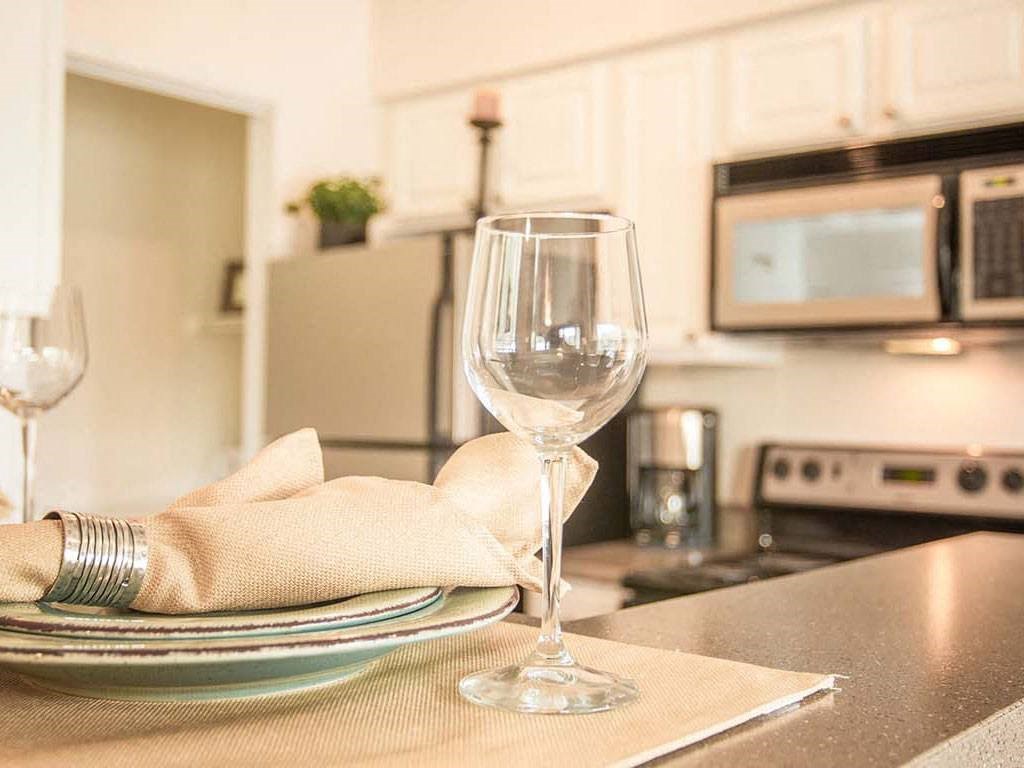 a kitchen with a plate and a wine glass on the counter