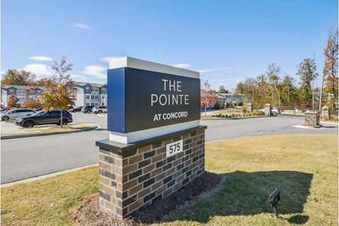 the pointe at concord sign at the corner of a parking lot