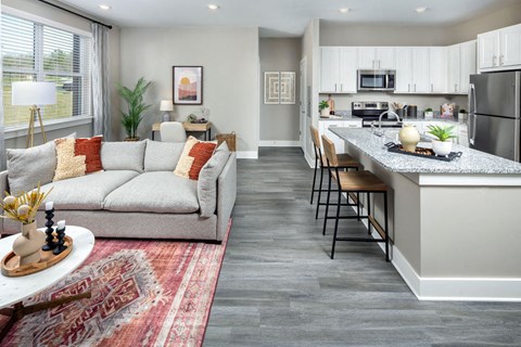 a living room and kitchen with a couch and a bar