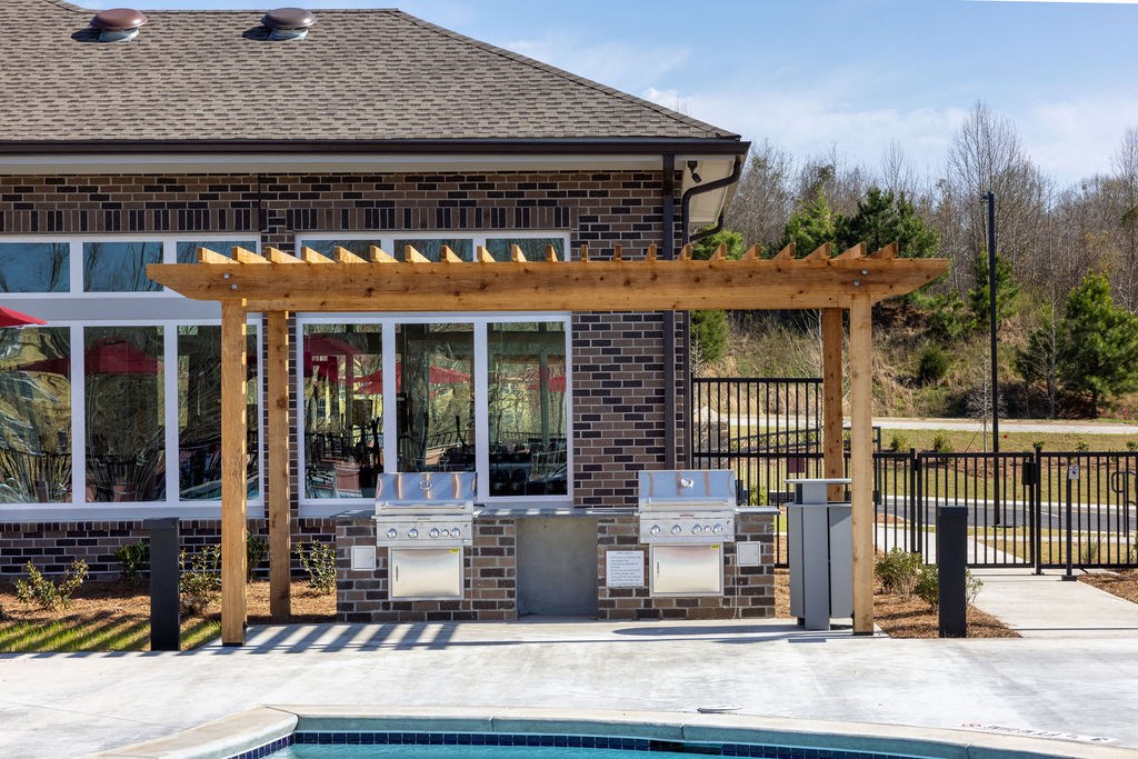 a patio with a pergola next to a pool
