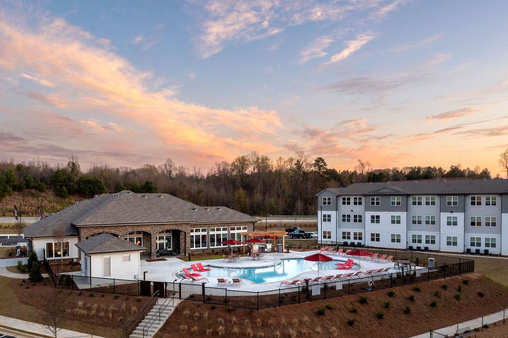 a view of a pool and a building at sunset