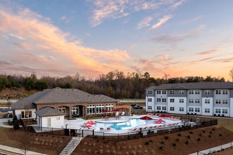 a view of a pool and a building at sunset