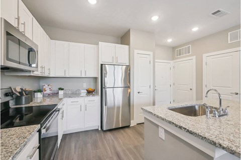 a kitchen with white cabinets and a stainless steel refrigerator