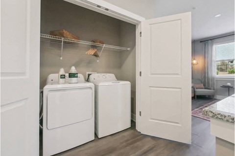 a white washer and dryer in a room with a closet and a window