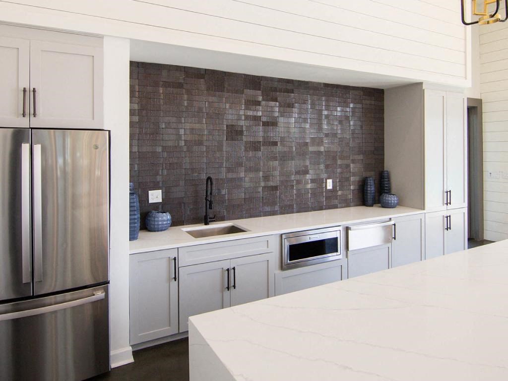 a kitchen with white cabinets and a stainless steel refrigerator