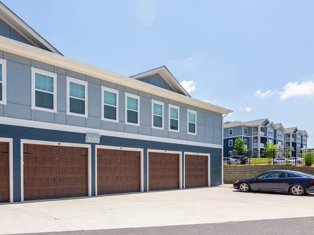 a building with three garage doors and a car parked in front of it