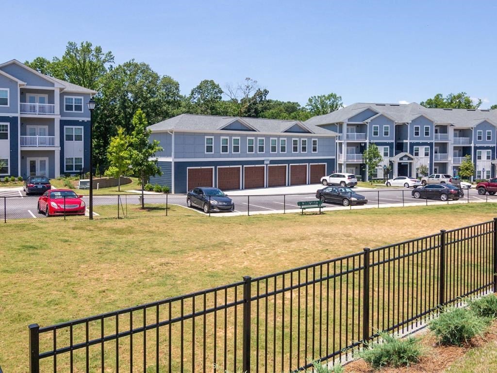 an image of an apartment complex with cars parked in front of it