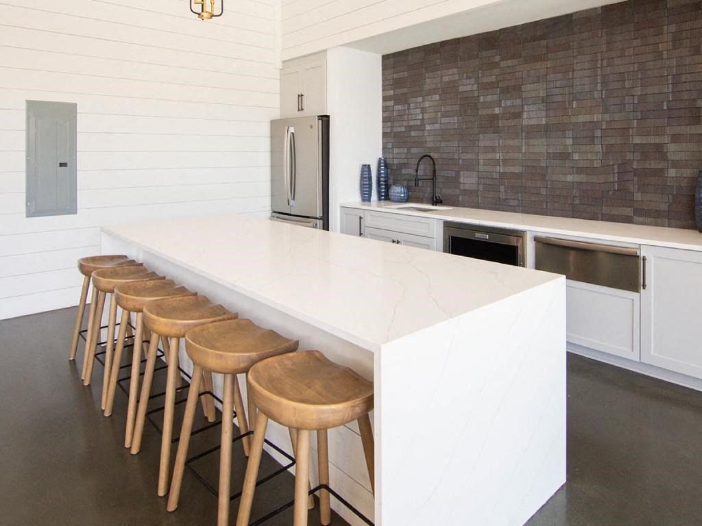 a kitchen with a white counter top and wooden bar stools