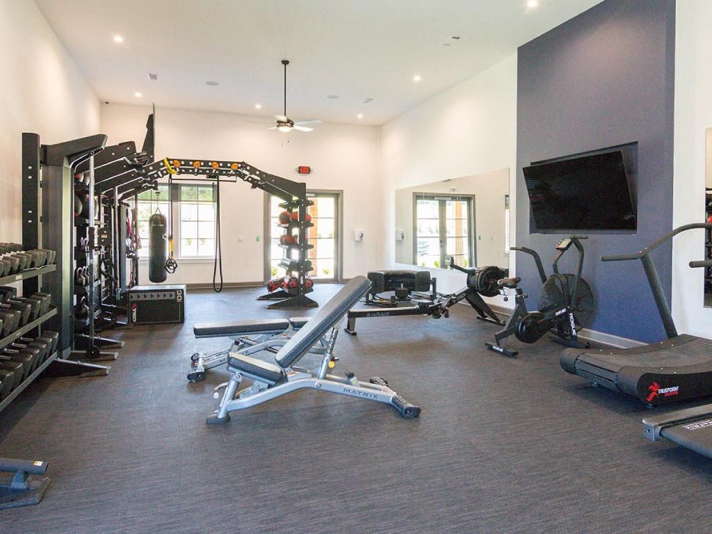 a home gym with weights and a tv