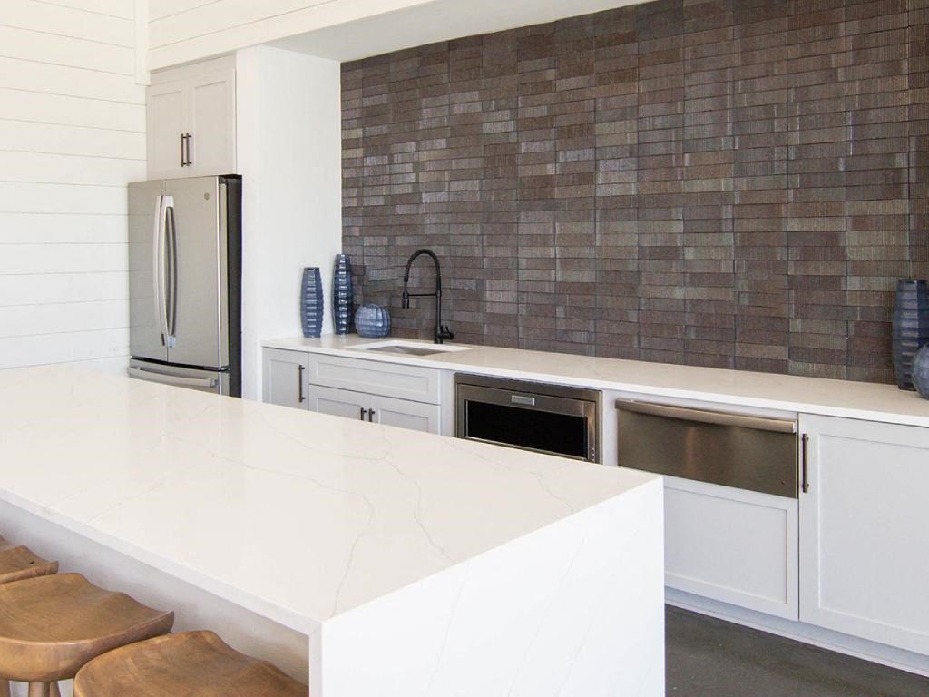 a kitchen with a white counter top and a stainless steel refrigerator