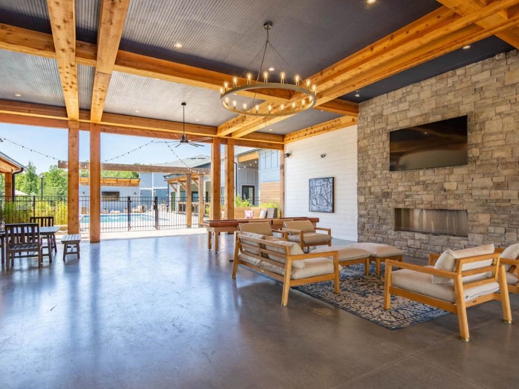 a large living room with a stone fireplace and wooden furniture