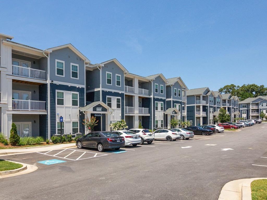 an empty parking lot in front of an apartment building