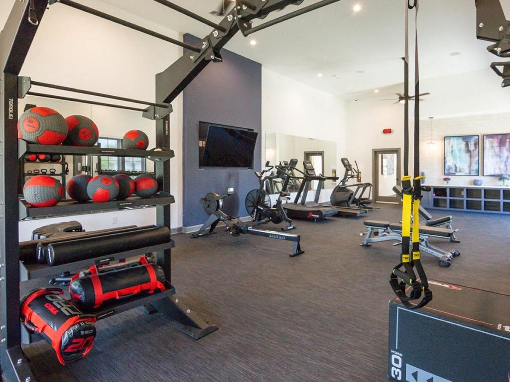 a gym with weights and a tv on the wall